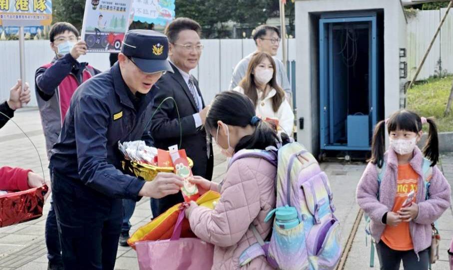 南港分局長周哲民率同仁至東新國小守護學童安全,並與東新國小校長李家旭共同發放新春小禮品給學童們。(記者薛秀蓮翻攝)