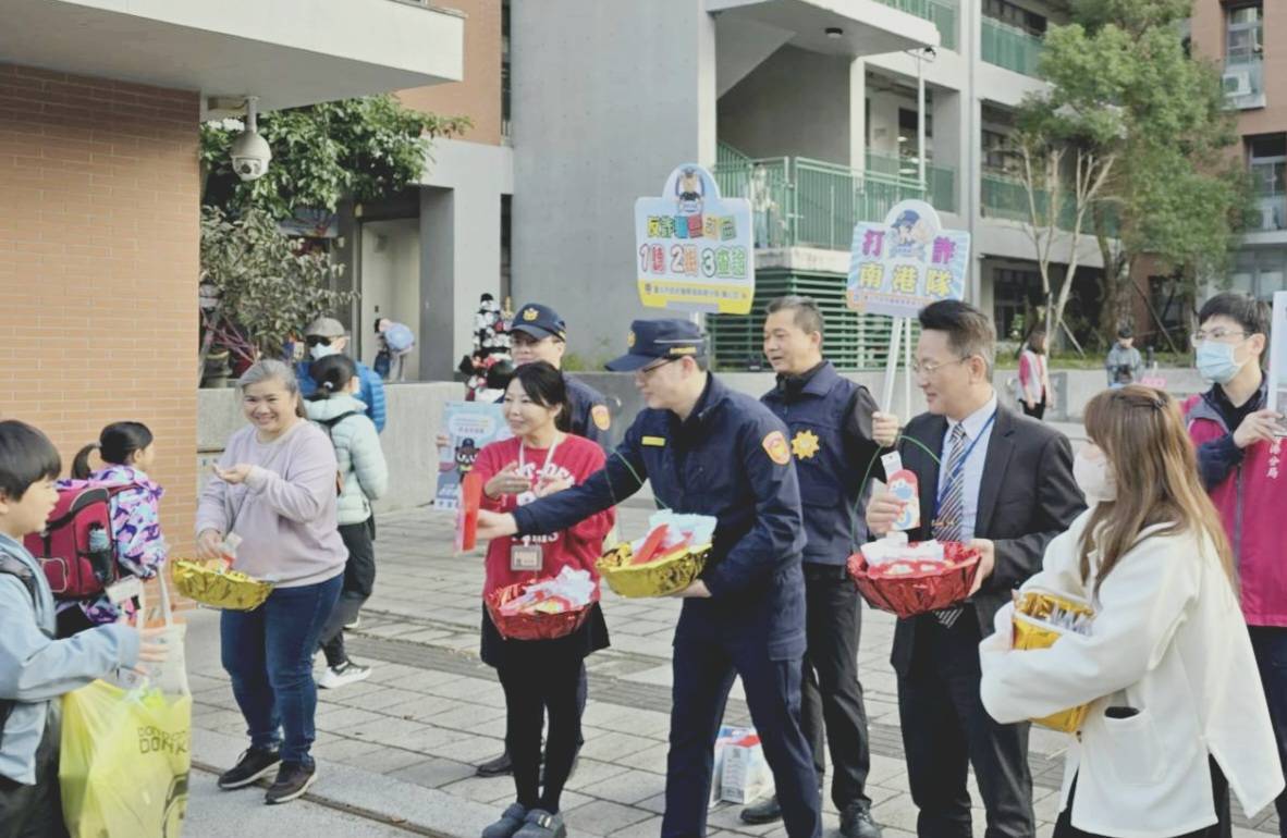 南港分局長周哲民率同仁至東新國小守護學童安全,並與東新國小校長李家旭共同發放新春小禮品給學童們。(記者薛秀蓮翻攝)