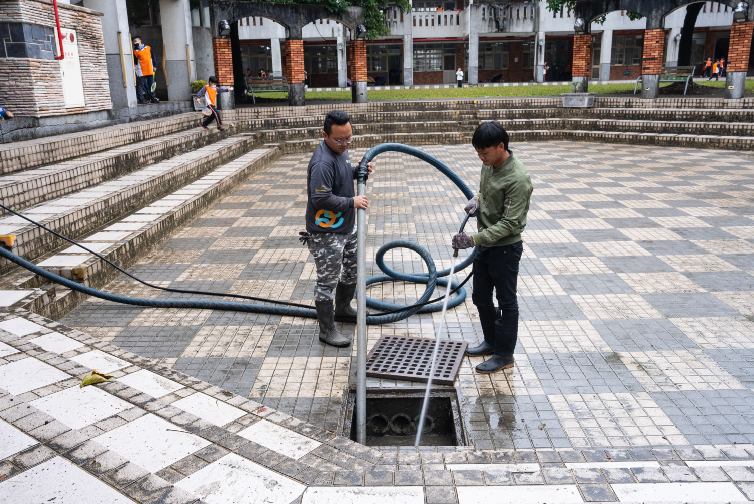 南投縣竹山鎮的前山國小校門遇雨即積水,遠雄志工為學童打造平坦校園路。(圖/ 遠雄文教公益基金會提供)