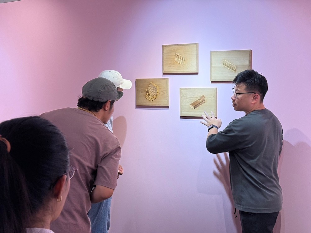 ▲導覽介紹參展的水韻木鑲(木片鑲嵌)展品。（圖/嘉義市政府提供）