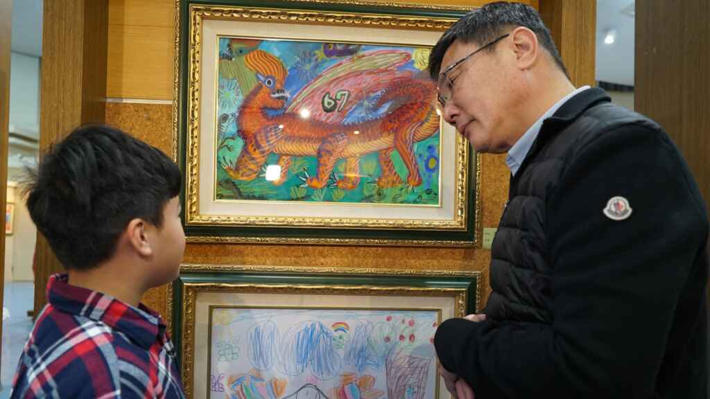 ▲鹿港鎮長許志宏細心聆聽孩子介紹作品。（記者林明佑攝）