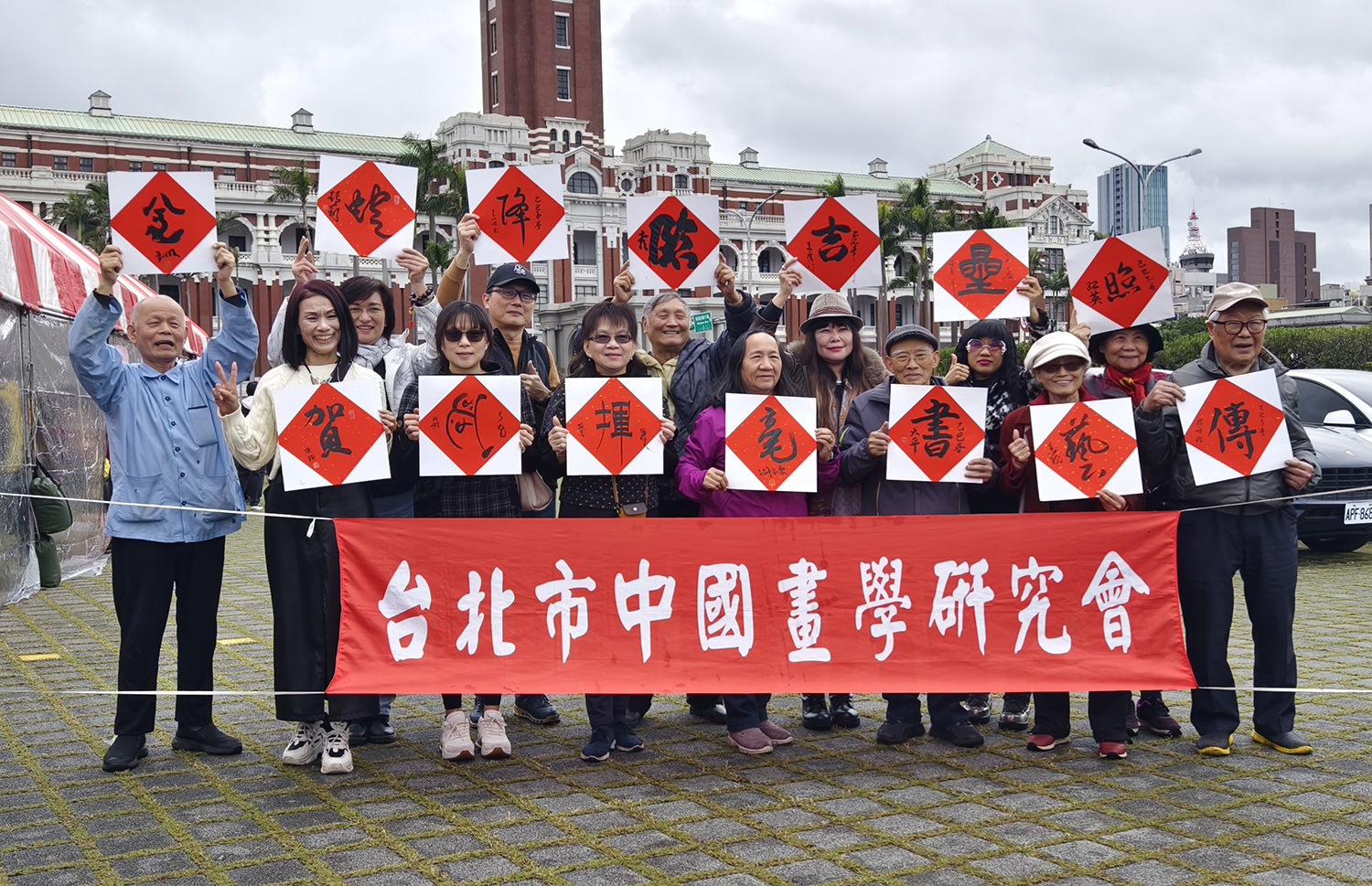 台北市中國畫學研究會開筆官們寫下吉祥對聯:「金蛇降臨吉星照,賀歲揮毫書藝傳」。(圖/湯溫謹攝)