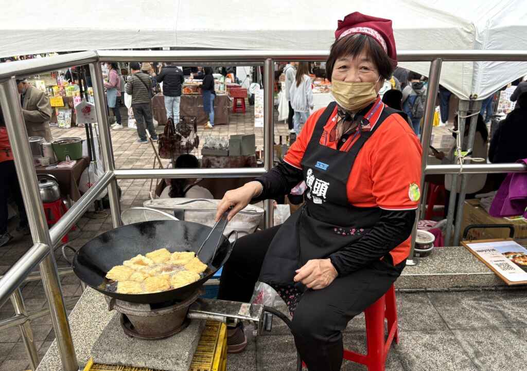 阿珍現炸豆包供顧客品嘗，展現多元就業技能。(記者廖承恩翻攝)