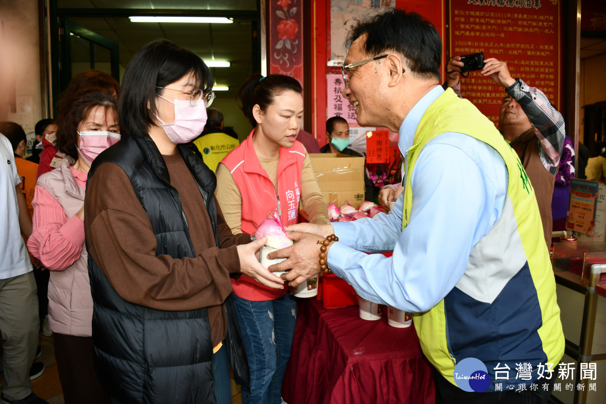 林世賢市長逐一發送壽桃與紅豆紫米桂圓粥給民眾分享慶祝土地公生的喜悅。圖/記者鄧富珍翻攝