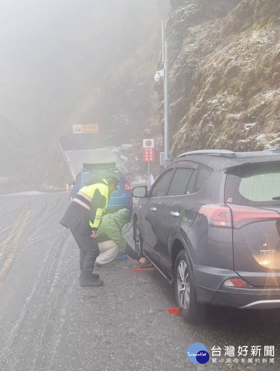 協助受困車輛加裝雪鏈。（仁愛警分局提供）