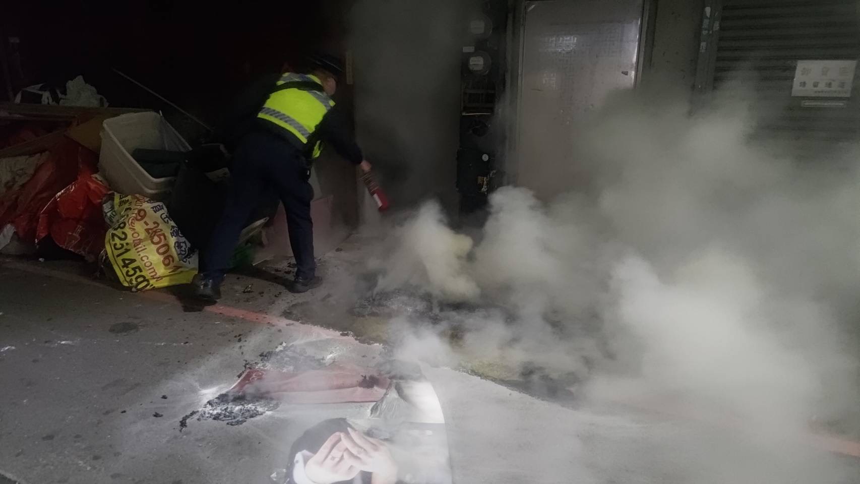 ▲圖說:員警取用隨車滅火器,努力撲滅已經起火燃燒的床墊與遮雨棚雜物 (圖/台中市政府 提供)