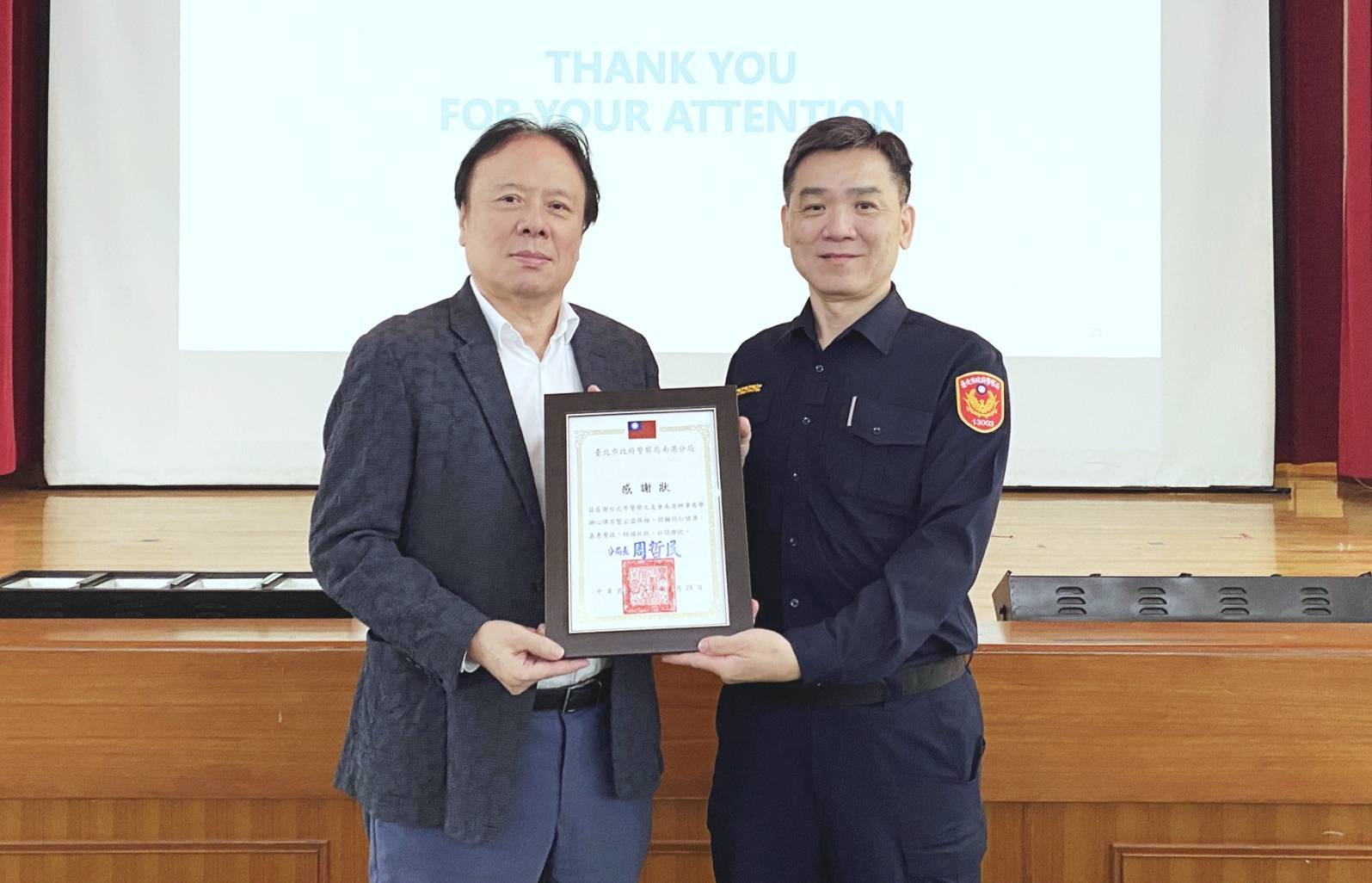 南港分局副分局長謝佾廷頒贈感謝狀給南港辦事處主任秦偉隆。(記者薛秀蓮翻攝)