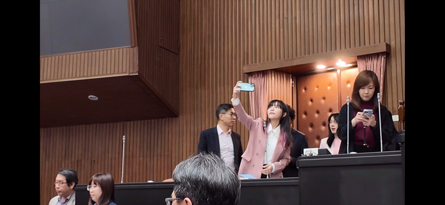 民進黨女立委黃捷在霸佔主席台現場自拍。(圖/葛如鈞國會辦公室)