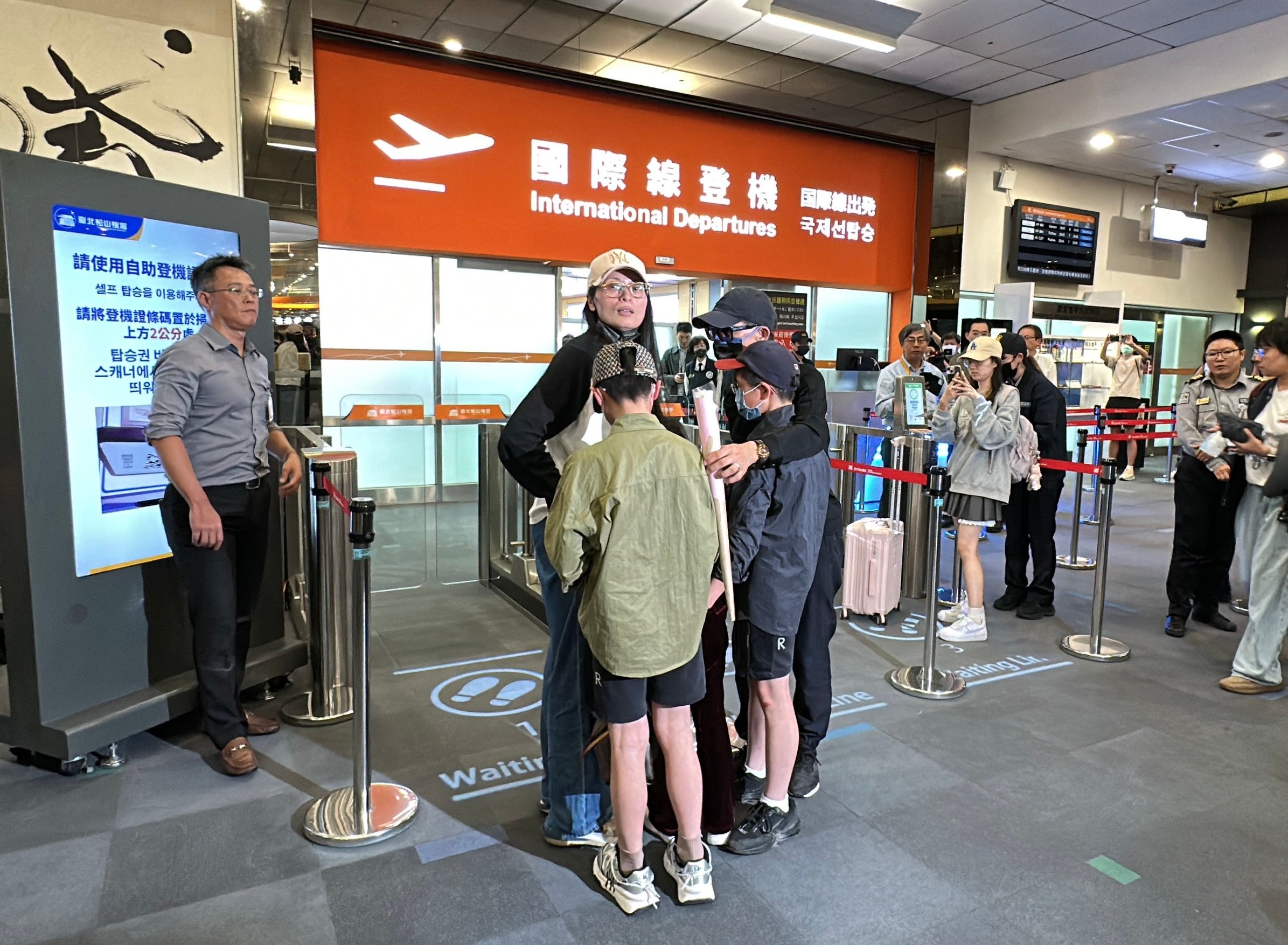 劉振亞25日晚間從松山機場搭機離台,她和丈夫、小孩在登機口擁抱道別。林啟弘攝