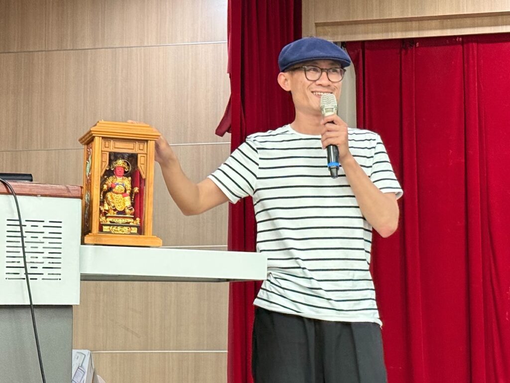 林宗範展示演出時必帶的「田都元帥」神像,象徵對傳統戲曲與表演藝術的尊重與敬畏。(圖/中山醫大提供)