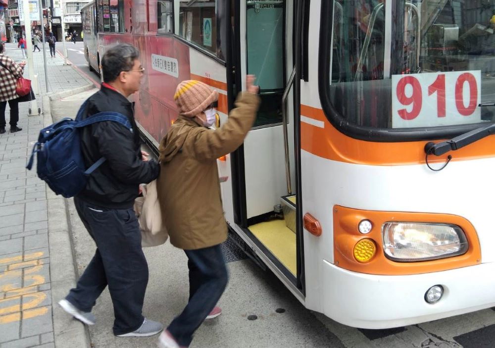 《圖說》胡輔導員(左)陪同孫爺爺的越配搭乘公車前往台北榮家,沿途貼心說明交通路線。〈新北榮服處提供〉