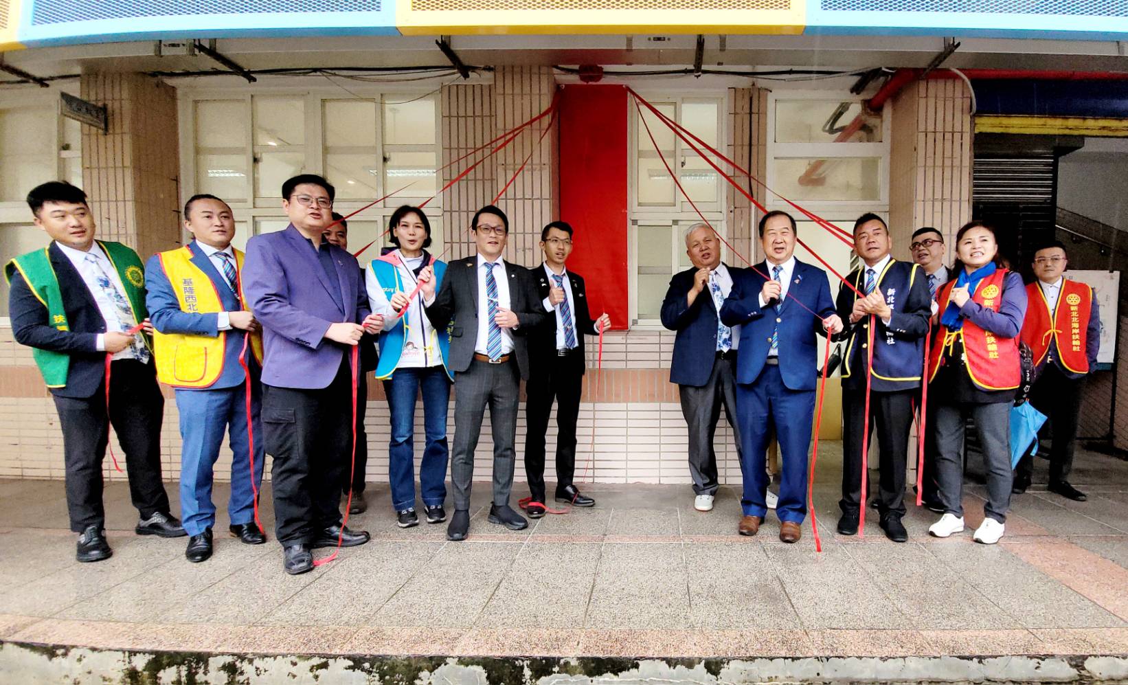 國際扶輪3490地區總監陳建勳(右5)率領基隆分區九個扶輪社長代表一同揭牌啟用，陳建勳說基隆分區九個扶輪社長期十幾年來都齊心一起完成許多社會服務，這次為教育提供扶輪學苑這樣一個優質的閱讀環境，培養更多孩子的良好習慣。