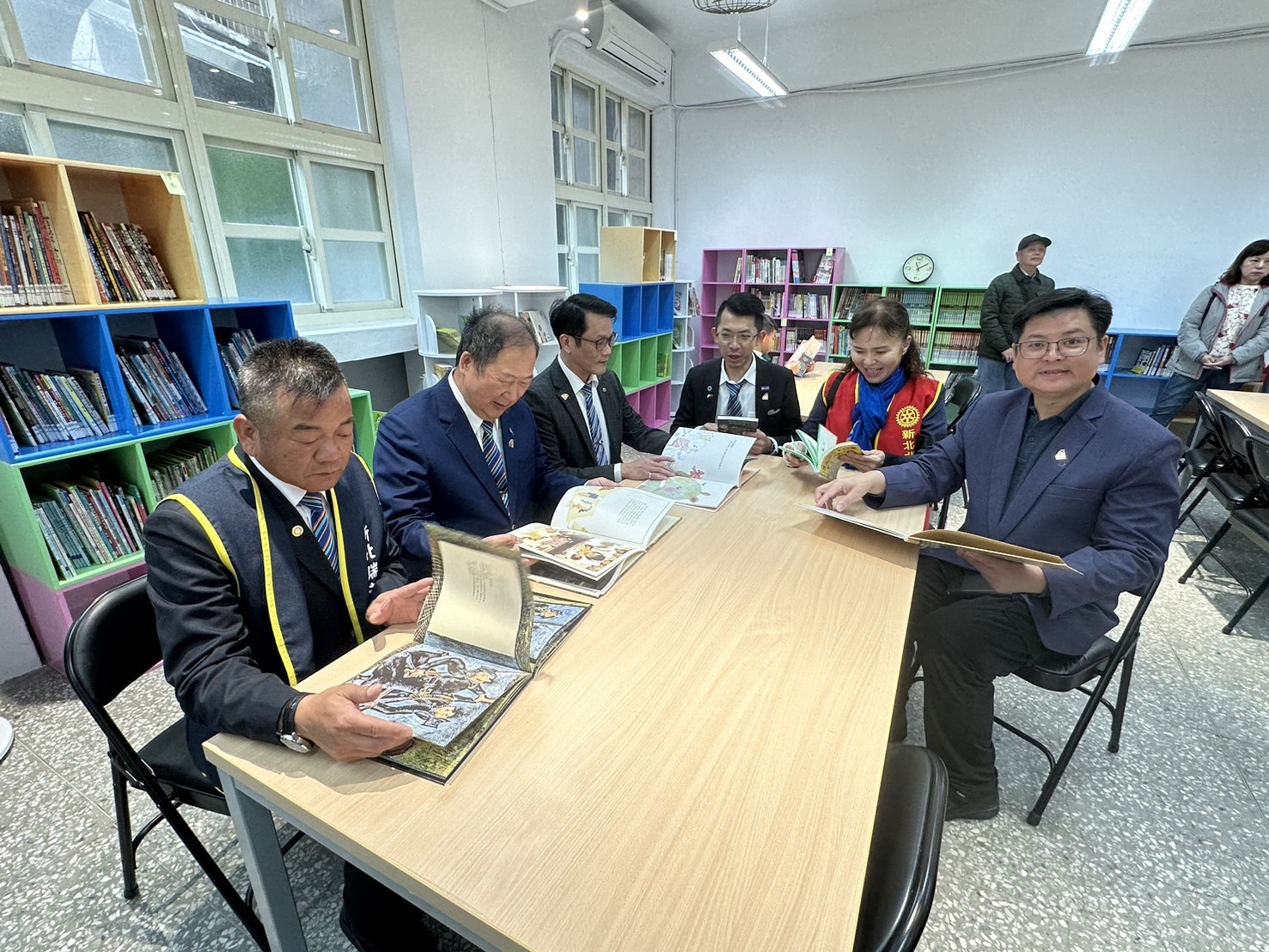 國際扶輪3490地區總監陳建勛(右2)及基隆分區助理總監吳金龍(前1)也率領大家一起選一本書來體驗一下現場的空間，除了測試燈光是否明亮，環境是否友善等，期望扶輪書苑這次可以提供優質的閱讀環境給基隆和平島社區居民。