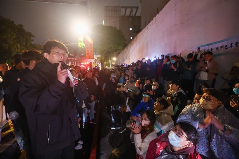 台灣民眾黨主席黃國昌(前左)29日傍晚起在台北看守所外靜坐,現場陸續聚集不少支持者。晚間近10時,柯文哲身體不適安排戒護外醫,消息傳出,黃國昌也向群眾喊話,希望大家早點回家休息。 中央社