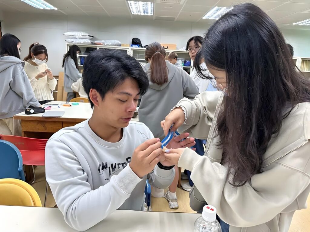 課堂上製作穿扣輔具,幫助手指靈活度不佳之患者獨立穿衣。(圖/中山醫大提供)
