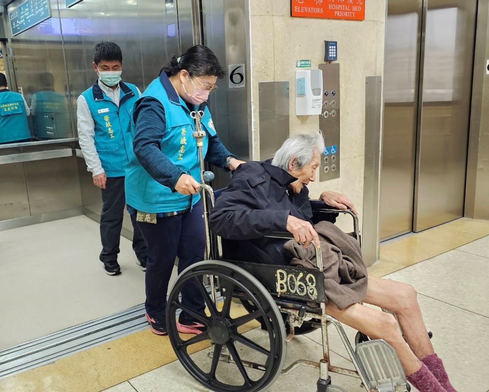 《圖說》榮欣志工以輪椅為劉伯伯代步。〈臺北市榮服處提供〉