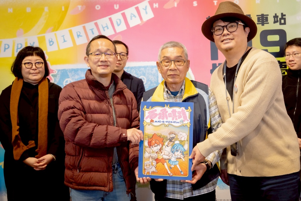 ▲唭哩岸文化工作室創辦人 林庚霖贈送《石承唭蹟-北投唭哩岸石探秘》繪本給北投四館。(圖/新北投車站提供)