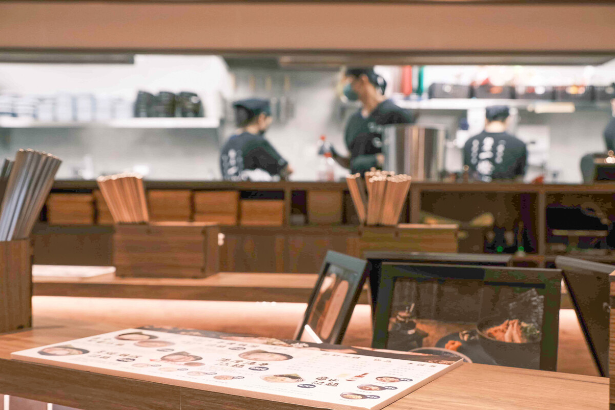 ▲麵屋一燈高雄夢時代店以海洋意象打造空間，藍染門簾與深藍壁磚展現靜謐氛圍，開放式吧檯傳遞東京職人精神，細節中體現對拉麵的極致講究。（圖/麵屋一燈提供）