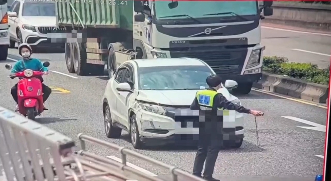 執勤員警在疏導過程中,突遭一輛白色自小客車擦撞警用巡邏機車。(圖/記者 黃荷琇翻攝)