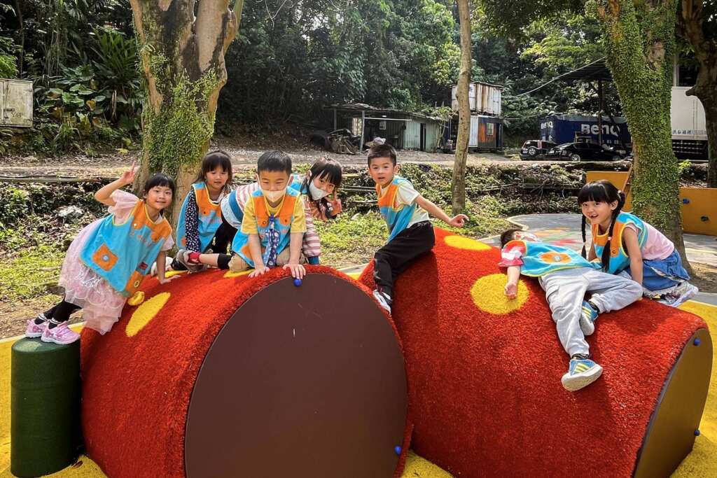▲幼兒園孩童在彩繪平衡管上攀爬，提升小朋友肢體協調。（土城區公所提供）