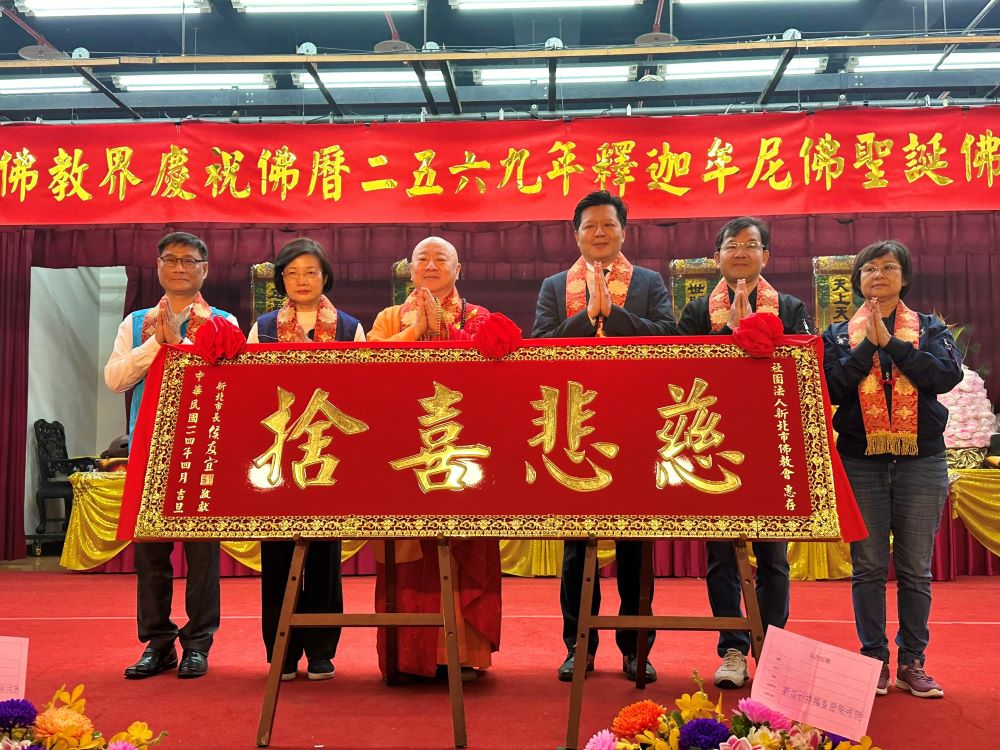 《圖說》副市長朱惕之代表侯友宜市長致贈匾額「慈悲喜捨」予新北市佛教會,感謝佛教界長年投入社會公益與市政推動。〈民政局提供〉