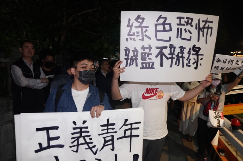 藍營人士15日晚間在新北檢外抗議，舉牌表達訴求。中央社