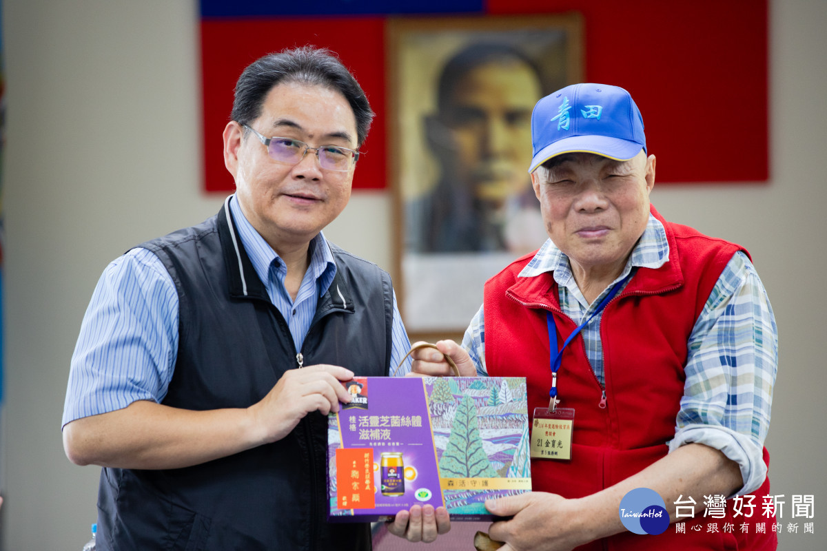 鞠宗顯處長(左)代表輔導會致贈與會83歲榮民金爺爺(右)活靈芝禮盒。