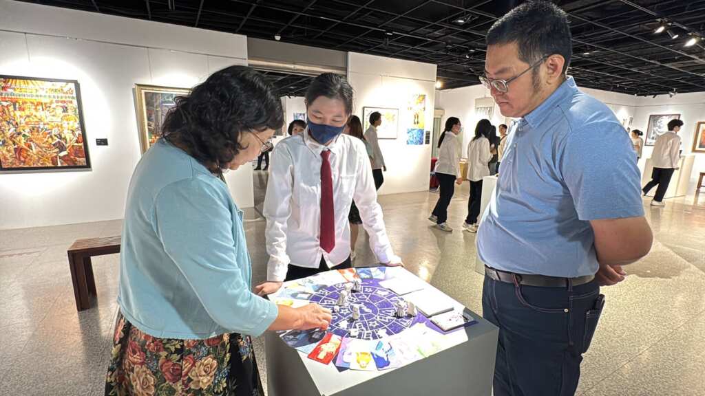▲參展同學為彰化藝術高中校長蔣秉芳與家長會長蕭啟群導覽解說作品。（記者林明佑攝）