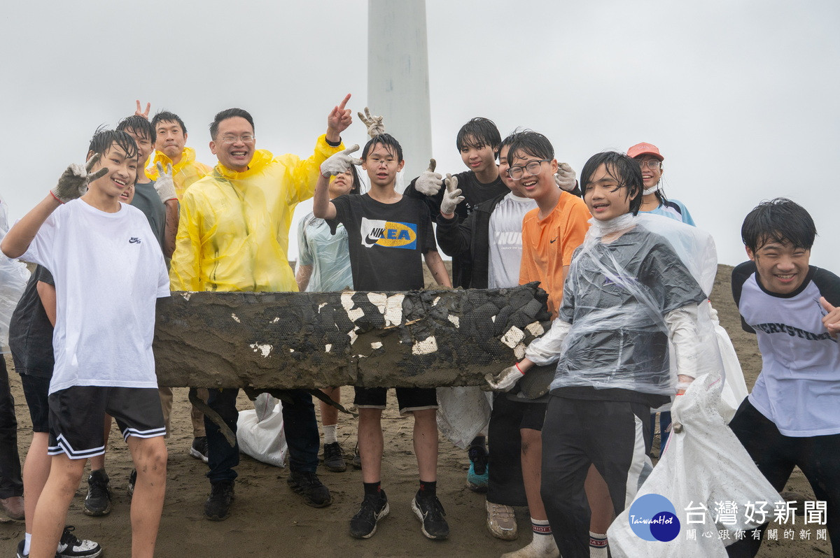 桃園市副市長蘇俊賓與草漯國中師生們於草漯沙丘冒雨淨灘。<br /><br />