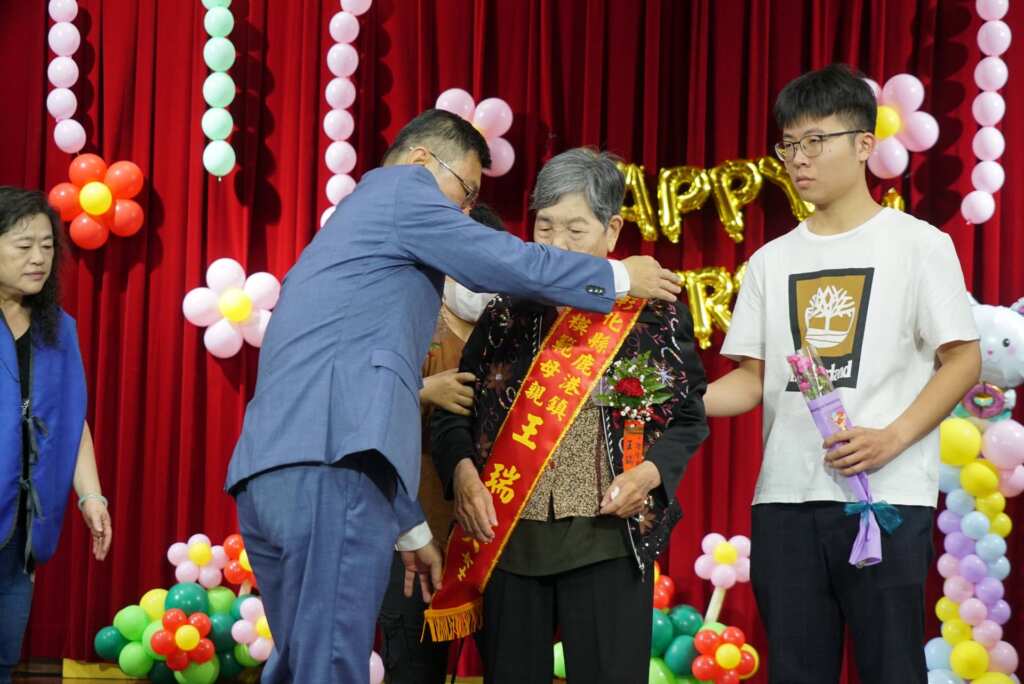 ▲鹿港鎮長許志宏為今年的模範母親們逐一披掛彩帶。（記者林明佑翻攝）