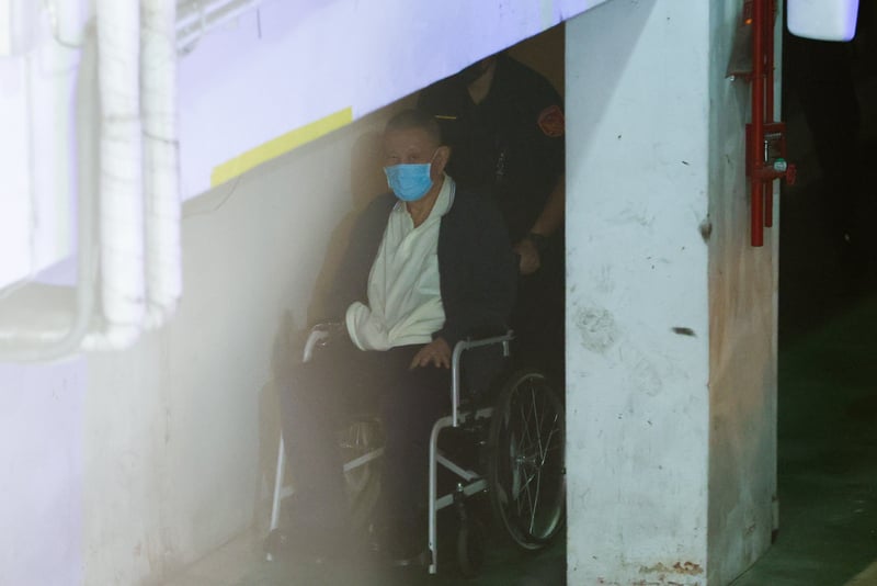 威京集團主席沈慶京(前),8日坐輪椅進入法院。中央社