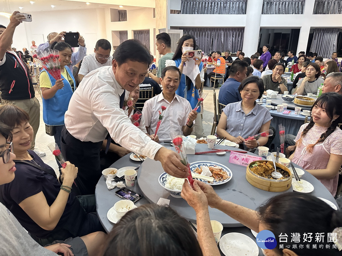 簡賜勝贈花予每來賓。(記者扶小萍攝)