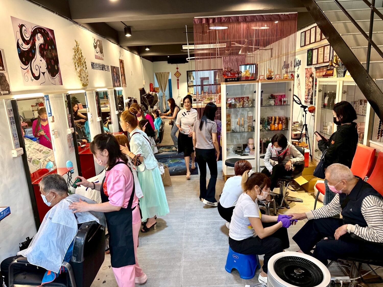 陳黃如老師一早就準備好康乃馨及養生涼麵，為社區民眾提供義剪服務。（圖/記者林照東攝）