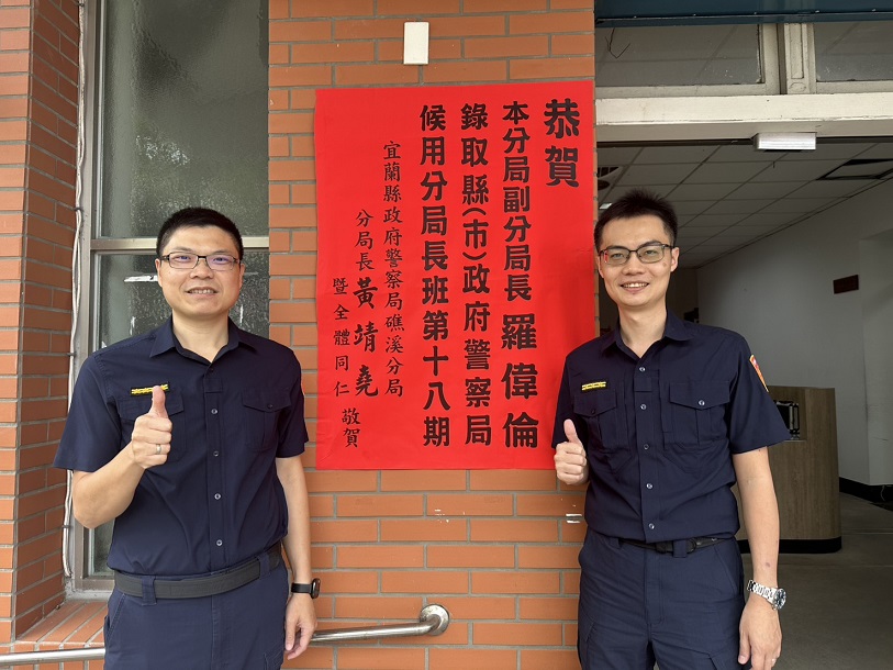 ▲礁溪分局副分局長羅偉倫(右)錄取分局長班，分局長黃靖堯(左)及同仁張貼紅榜祝賀。
