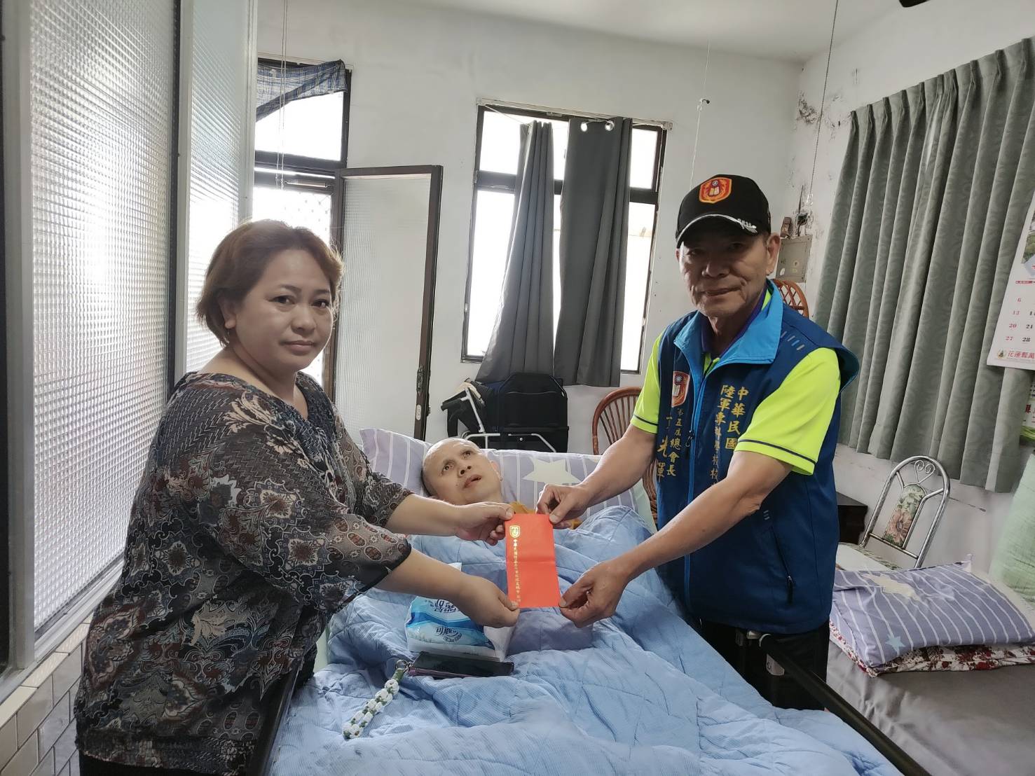 校友總會總會長黃光輝代表致贈禮金慰助陳姓老榮民,並由照顧他的胞妹代表接受。(圖/中華民國陸軍專科學校校友總會)