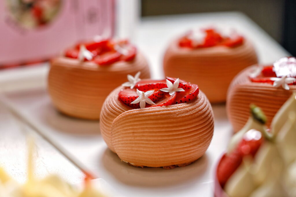 以Adamance 艾達曼覆盆子果泥製作滑順奶霜,搭配杏仁榛果奶油酥波蘿蛋糕體,交織出果香濃郁、層次分明的少女系甜點。