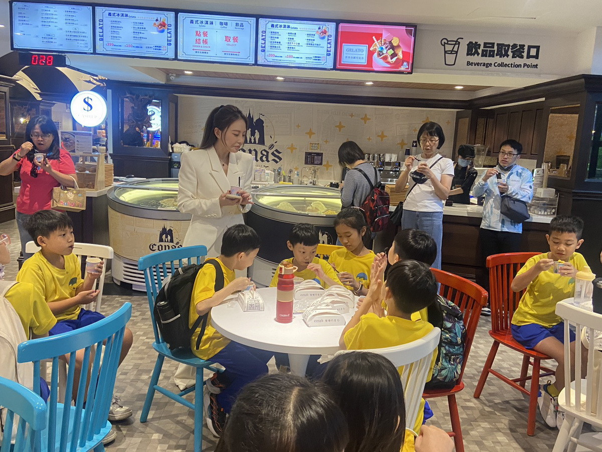 學童快樂的品味著冰淇淋。(南投縣婦幼協會提供)<br /><br />