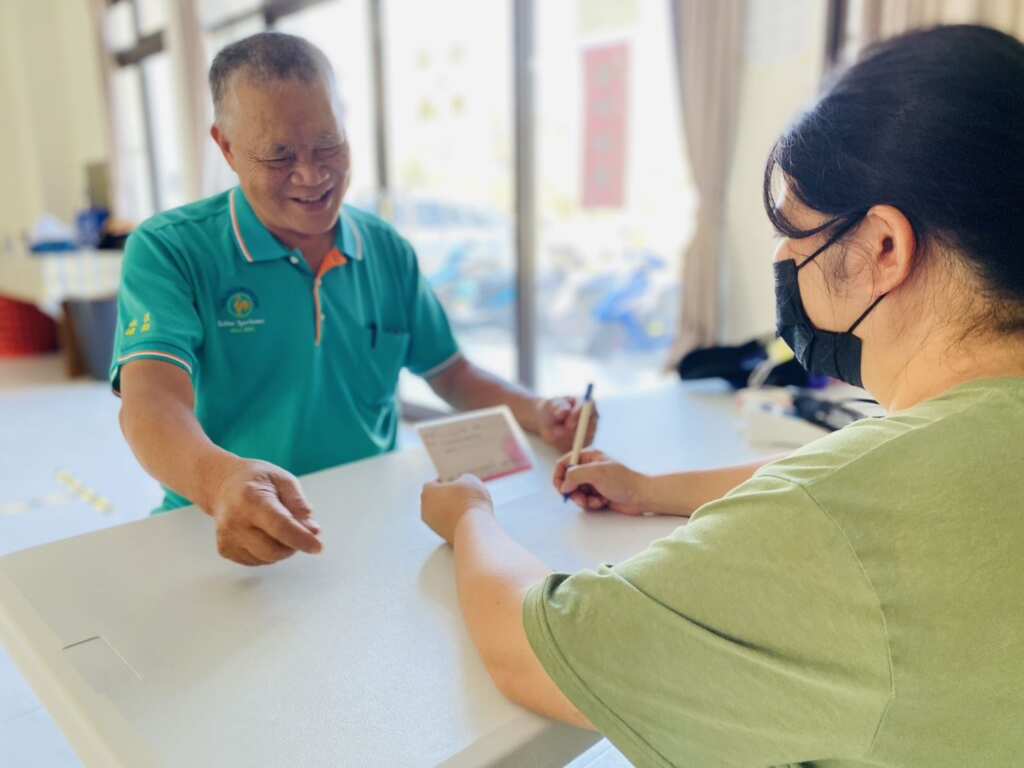 ▲協助長者填領取重陽敬老金指定匯款帳戶。(屏東縣社會處提供)