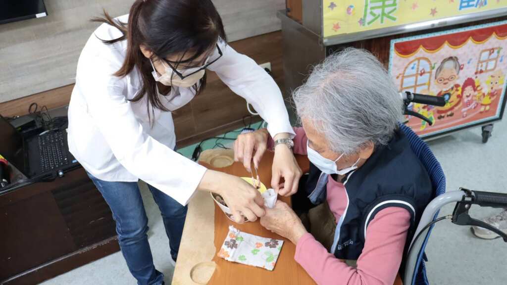 ▲衛福部彰化醫院中醫師黃鋒榮與3位藥師今日特別前往護康護理之家，攜帶9種中藥材，與長輩們一起手作端午香包，既是民俗，也能驅蚊防蟲，現場洋溢著草本清香和歡樂。（記者林明佑翻攝）