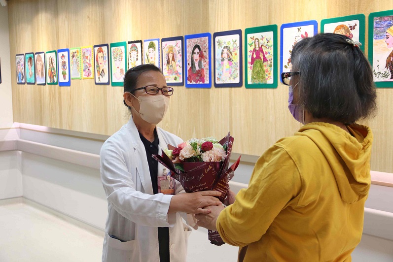 ▲迦南護理之家4日上午為CC阿嬤「忻愛‧忻旅」畫展舉辦小而美的開幕式,身為護家巡迴醫師的台東基督教醫院家庭醫學科醫師陳淑媜(左)代表迦南送花祝福。