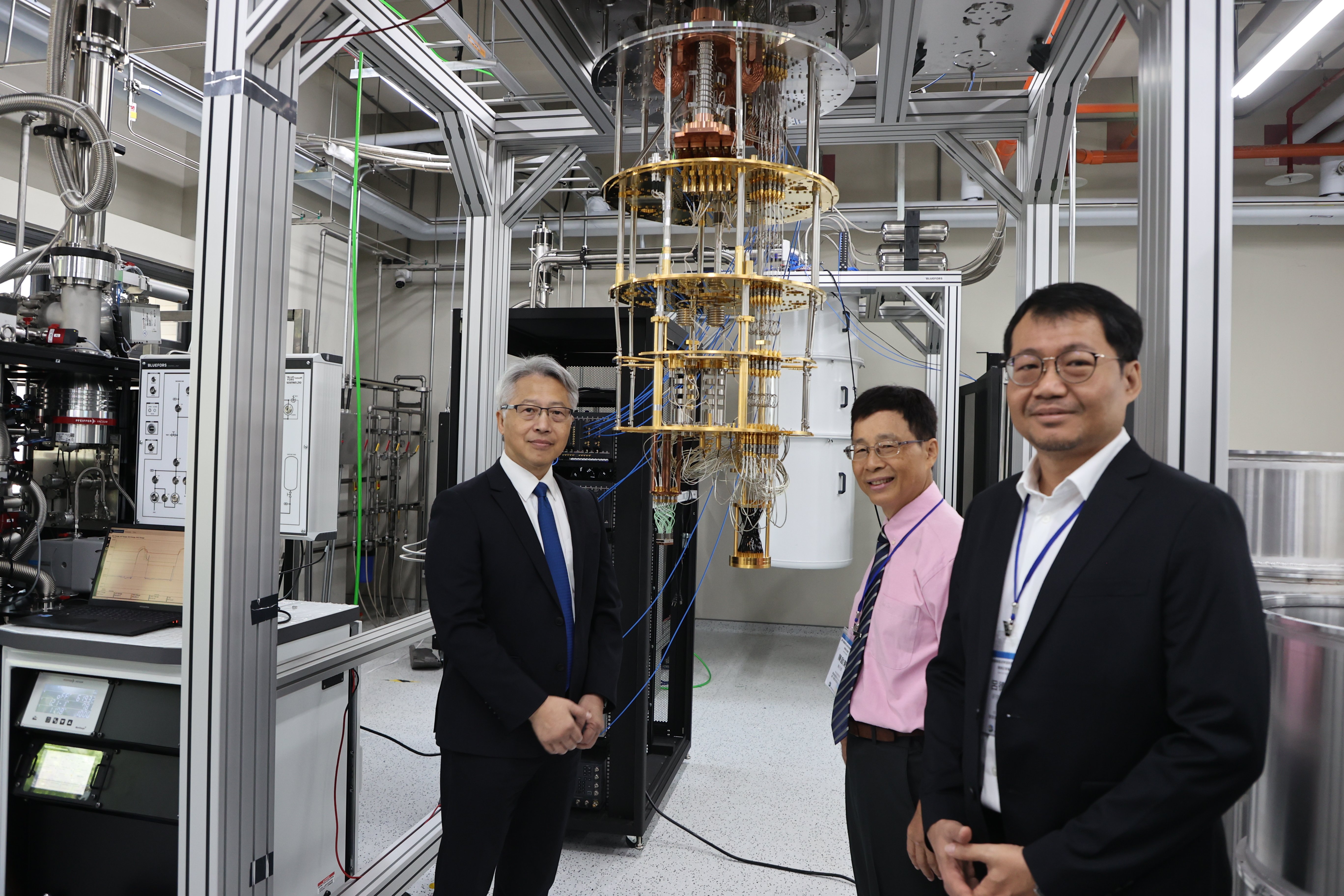 中研院廖俊智院長（左1）與量子電腦研發團隊在設備前合影。民眾提供