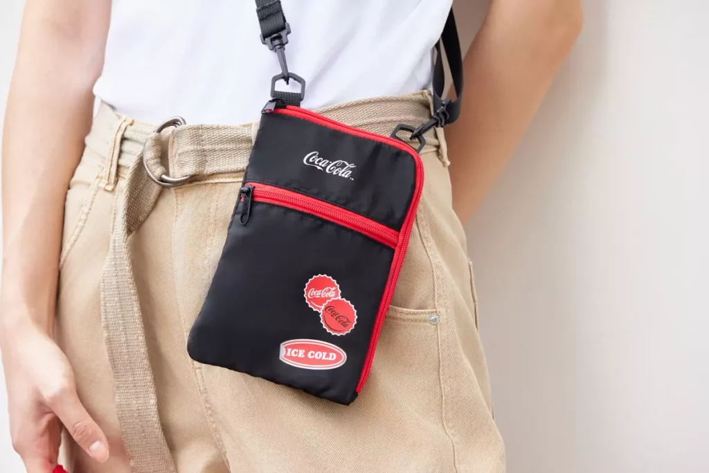 「Coca-Cola ™同諧一起玩 旅行包組」旅行護照包簡約俐落設計,並融入「可口可樂」品牌的經典風格。