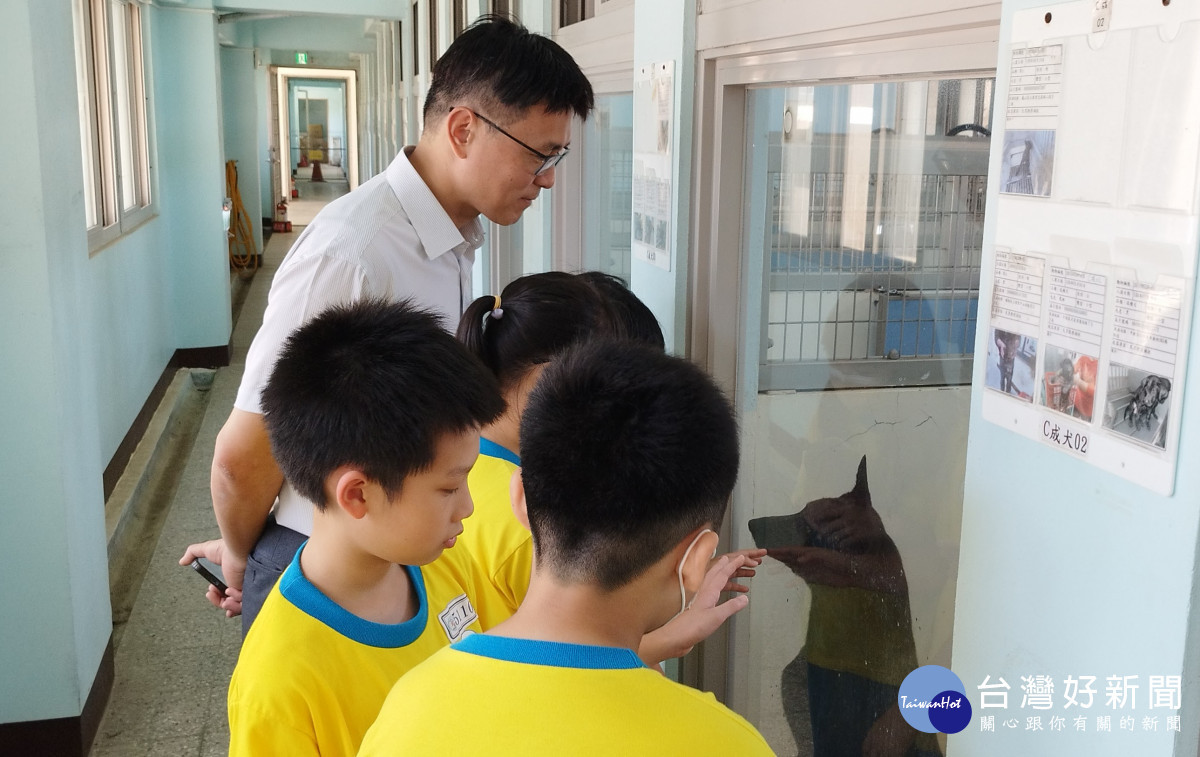動保社小朋友參訪園區犬舍,與待領養的黑犬互動