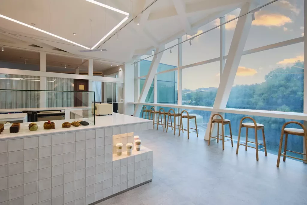 Rolling Dough 咖啡廳座位區擁有臺北市區少見的低空航道景觀,提供「北美館看飛機」的絕佳視角。(MMHG 提供)