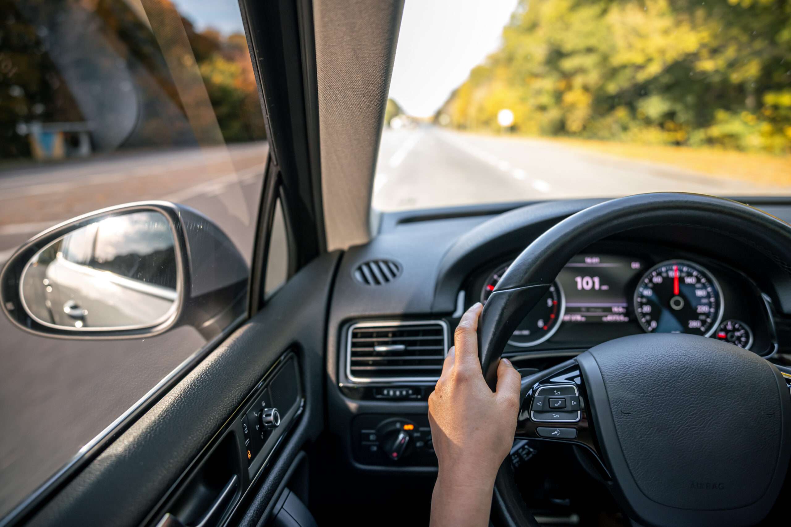 woman drivers hands steering wheel inside car scaled