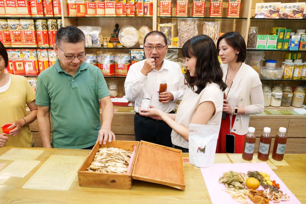 五家經典店鋪華麗變身 「老店新妝」翻轉新莊廟街 3 《圖說》「晉義蔘藥行」準備適合夏日冰涼飲品,退火消暑的「日日養潤茶」以及自製的八仙果給侯市長品嚐。〈青年局提供〉