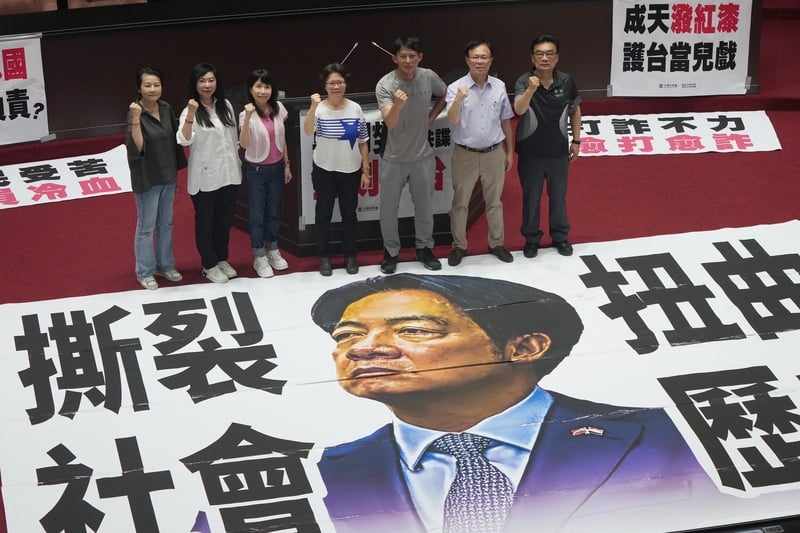 民眾黨團徹夜排隊為搶先遞案,4日一早民眾黨立委進入議場後將標語貼在議場中央並合影。中央社