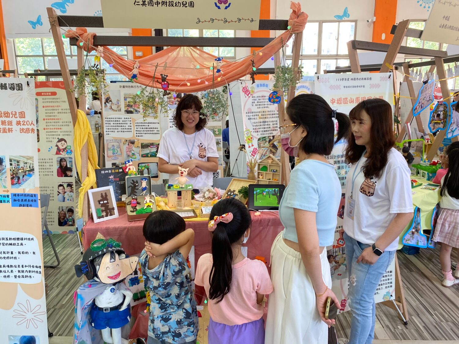許多家長帶著學齡前幼童出席,看著攤位琳琅滿目的展示,笑得目不轉睛。(記者包克明 攝)