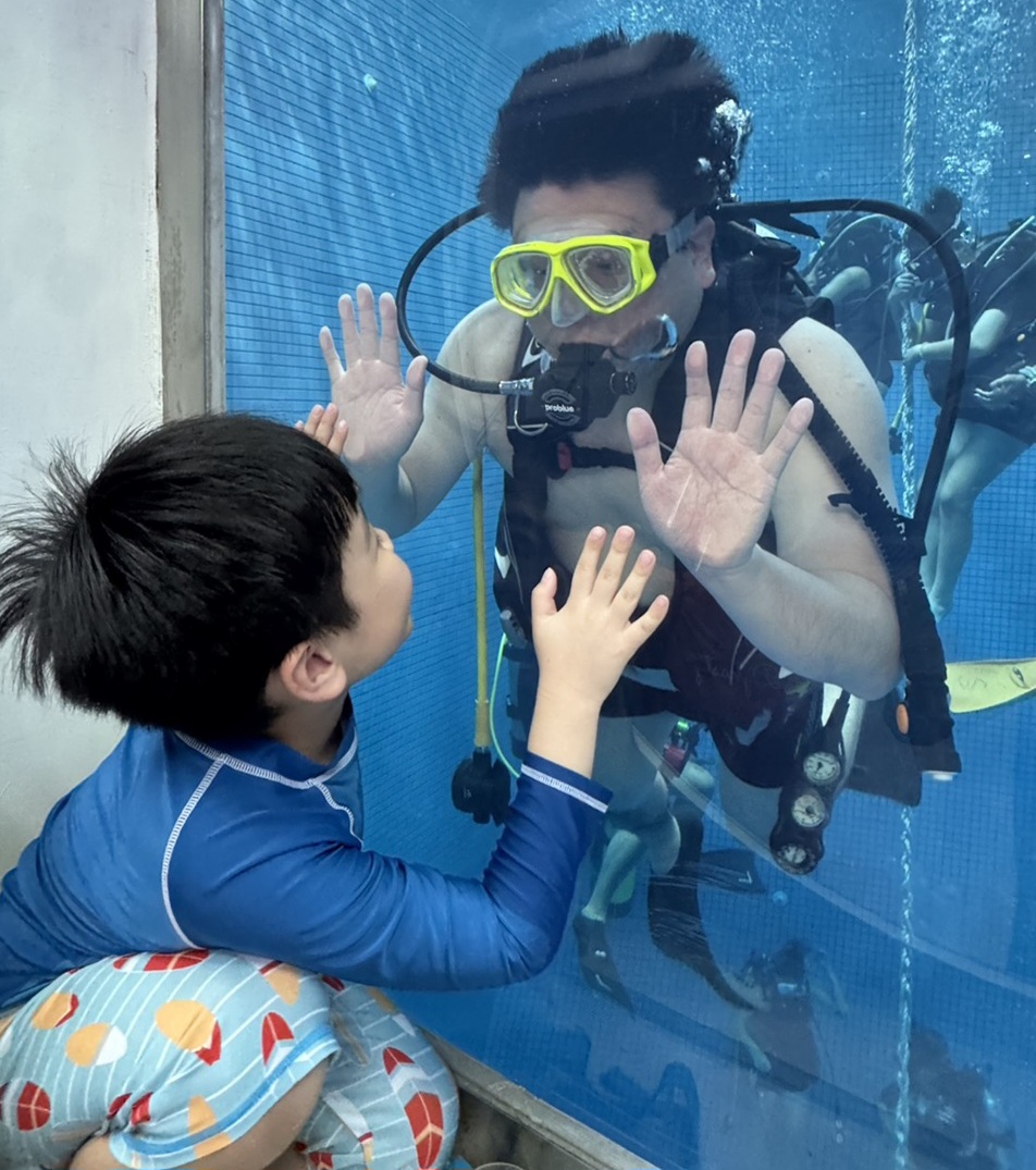 ▲潛水體驗營吸引親子共同參加,圖為爸爸著潛水裝備在水底與孩子打招呼,直呼是非常難得的經驗。