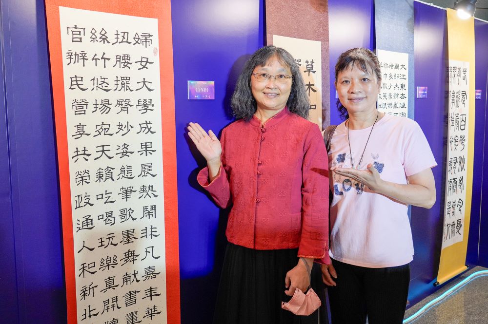 撐起一片天 新北婦女大學成果展詮釋自信成長 7 《圖說》婦女大學學員蕭美君(左)為今年成果展親自創作了一幅詩作,特別與老師(右)合影留念。〈社會局提供〉